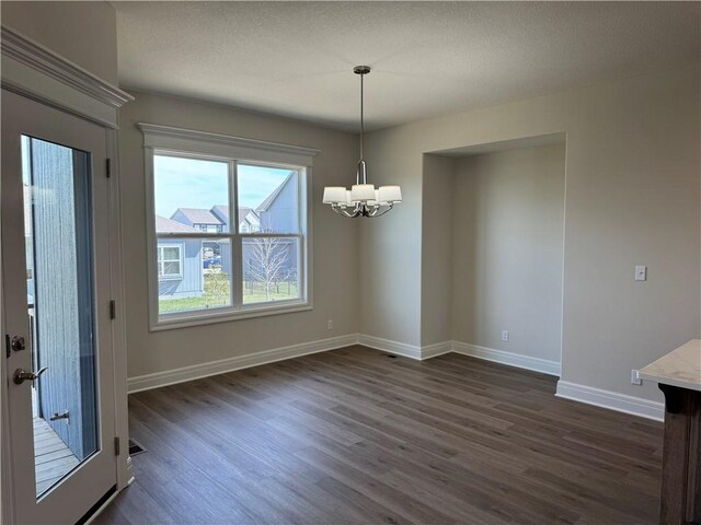 25297 W 149th Ter, Olathe, KS 66061 - unfurnished dining area with a chandelier, dark wood finished floors, and baseboards