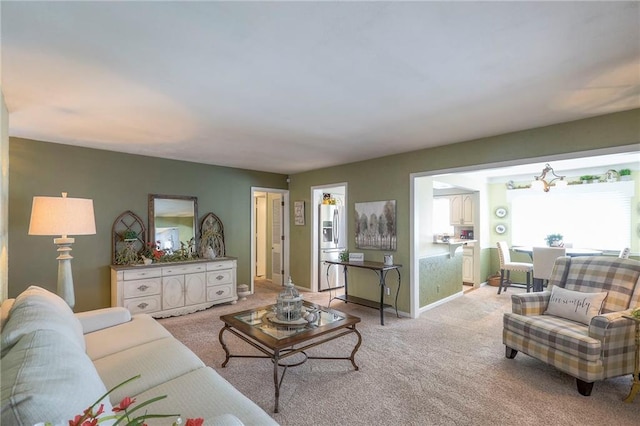 living room featuring baseboards and light colored carpet