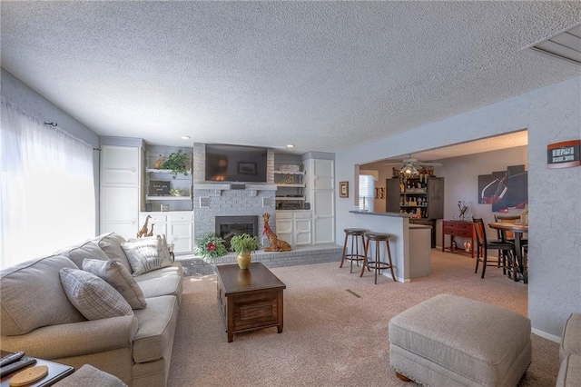 living room featuring a fireplace, a textured ceiling, and carpet flooring