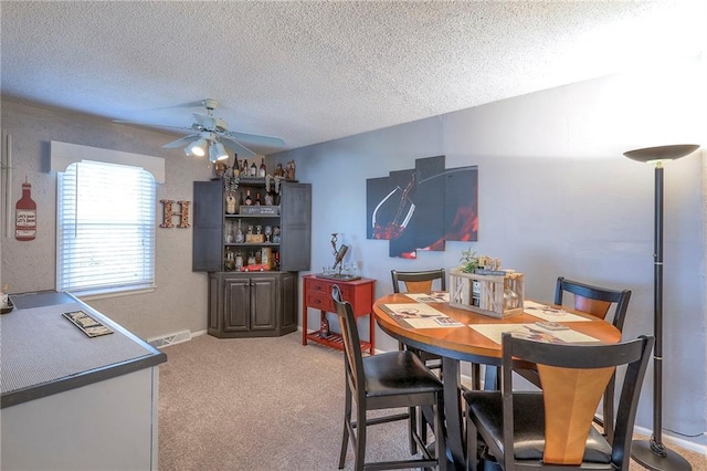 dining area with visible vents, carpet flooring, ceiling fan, a textured ceiling, and baseboards