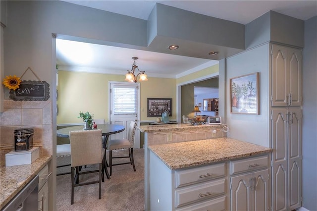 kitchen featuring light stone counters, pendant lighting, crown molding, light colored carpet, and stainless steel dishwasher