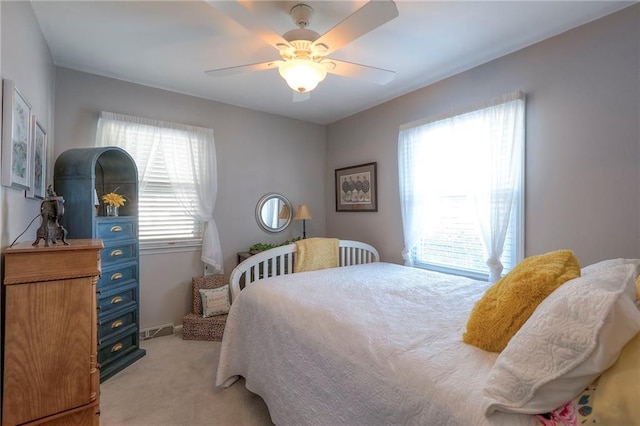 bedroom featuring a ceiling fan, light carpet, and visible vents