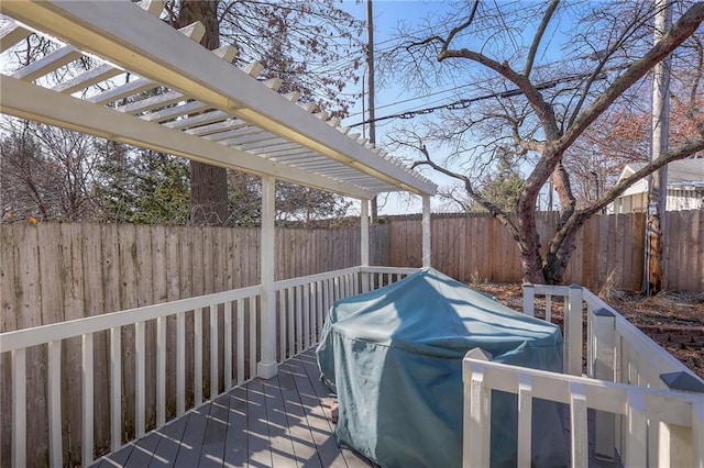 wooden deck with a fenced backyard and a grill