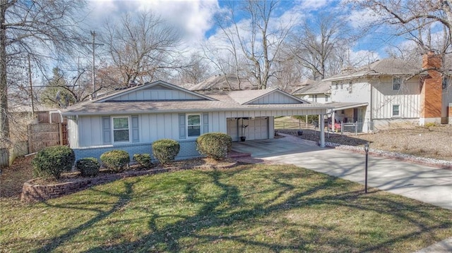 view of front of house with board and batten siding, a front yard, brick siding, and driveway