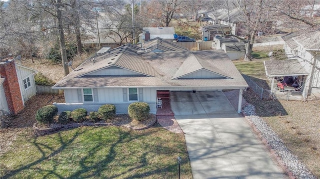 view of front of property with brick siding, a shingled roof, fence, concrete driveway, and a front lawn