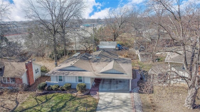 view of front facade featuring a garage, driveway, and a shingled roof