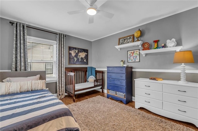 bedroom with ornamental molding, dark wood finished floors, and ceiling fan