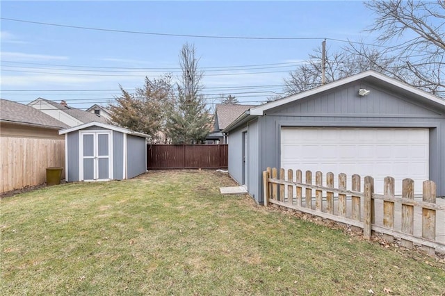 view of yard featuring a garage, a fenced backyard, a shed, and an outdoor structure