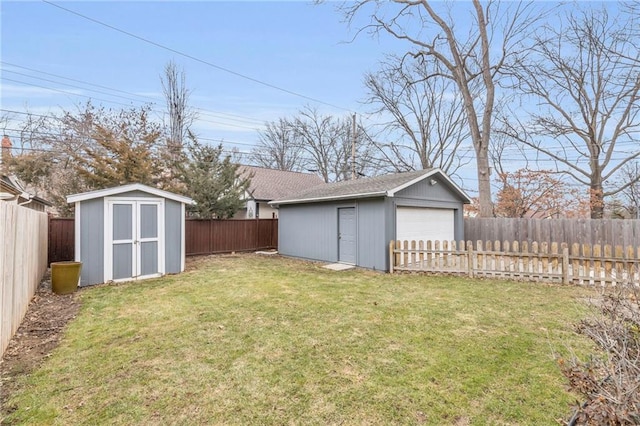 view of yard featuring an outbuilding, a fenced backyard, a detached garage, and a shed