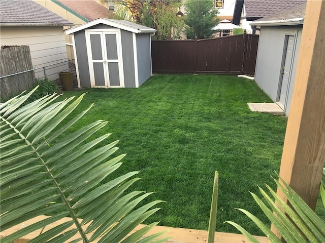 view of yard with an outbuilding, a fenced backyard, and a storage shed