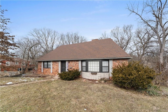 view of front facade with brick siding, stone siding, roof with shingles, a front lawn, and a chimney