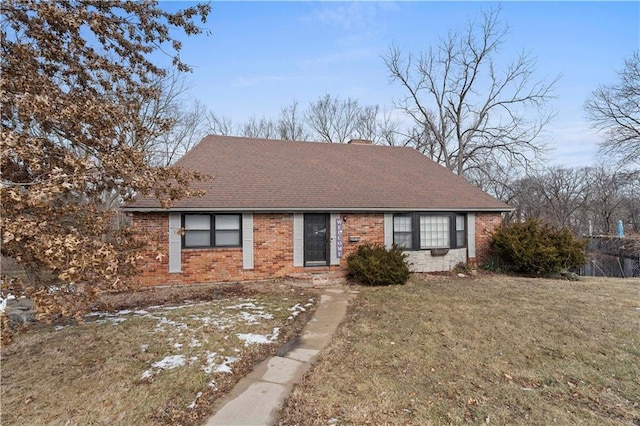 ranch-style home featuring roof with shingles, a front lawn, and brick siding