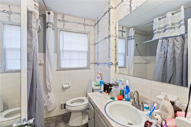 full bathroom featuring tile walls, visible vents, a textured ceiling, and toilet