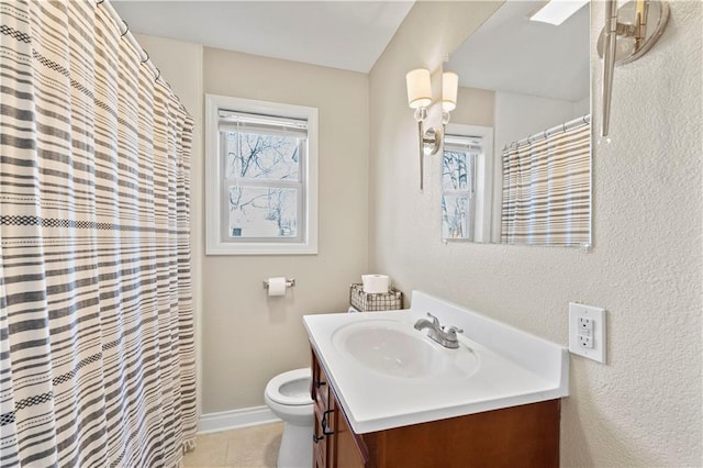 bathroom featuring toilet, tile patterned flooring, a wealth of natural light, and vanity