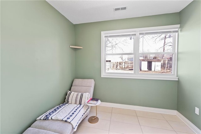 sitting room featuring baseboards, visible vents, and tile patterned flooring