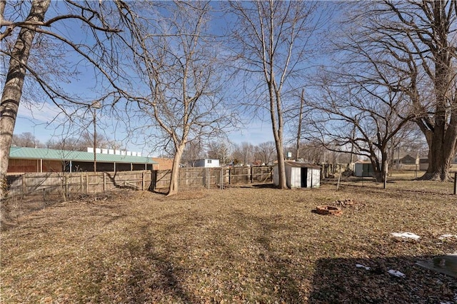 view of yard featuring an outbuilding, fence, and a shed