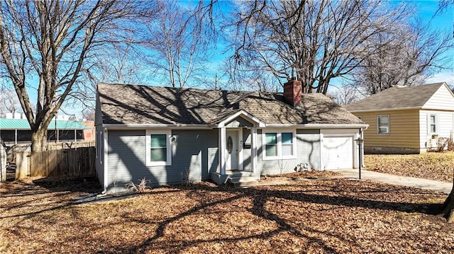 view of front of house featuring brick siding, a chimney, fence, a garage, and driveway