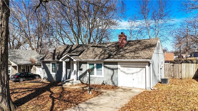 view of front of house with an attached garage, cooling unit, fence, driveway, and a chimney