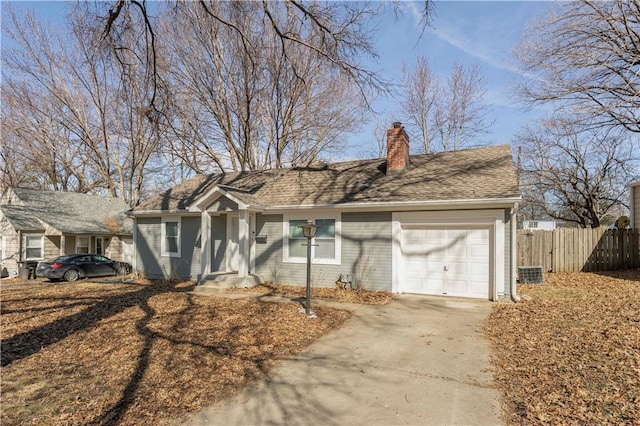 single story home featuring a chimney, a shingled roof, concrete driveway, fence, and a garage