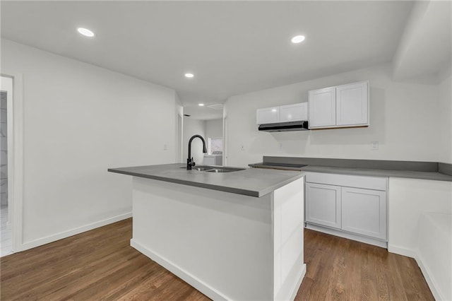 kitchen featuring white cabinetry, an island with sink, sink, dark hardwood / wood-style flooring, and black electric cooktop