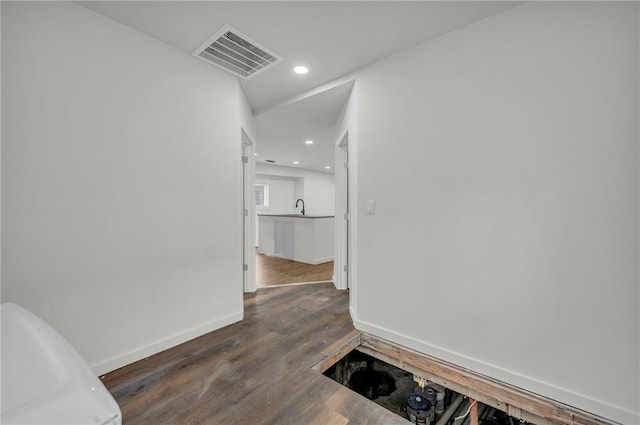 hallway featuring sink and dark wood-type flooring