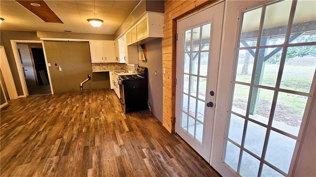 kitchen with white cabinetry, dark hardwood / wood-style floors, range with gas stovetop, and backsplash