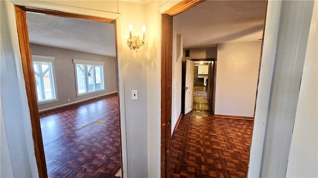 corridor with dark parquet floors and a textured ceiling