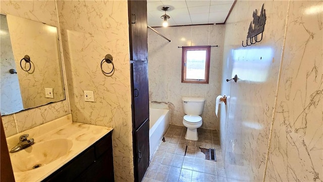 bathroom featuring a washtub, vanity, and toilet