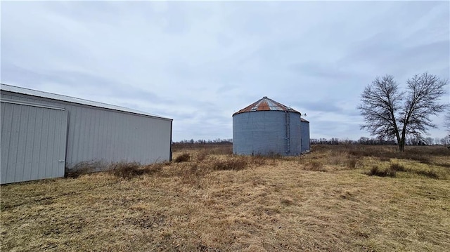 view of outbuilding with a rural view and a lawn