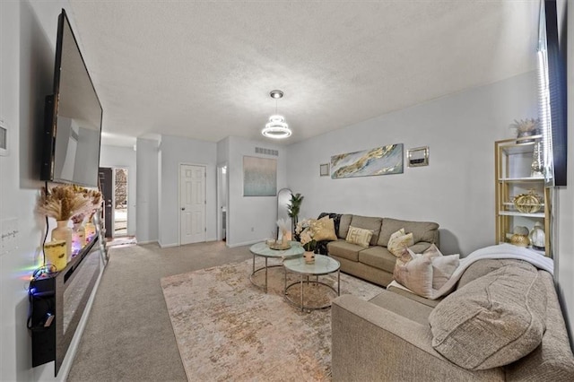 living room with a textured ceiling, baseboards, a chandelier, and light carpet