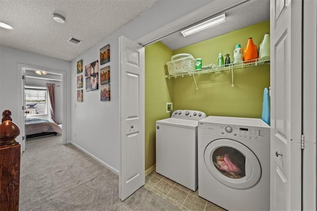 laundry area featuring a textured ceiling, laundry area, carpet floors, and washing machine and clothes dryer