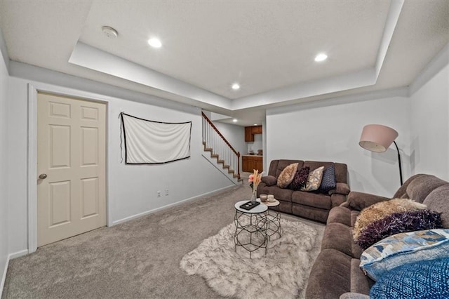 carpeted living area featuring stairway, recessed lighting, baseboards, and a tray ceiling