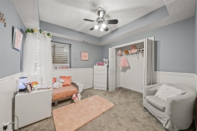 bedroom with a ceiling fan, a closet, carpet floors, and a textured ceiling