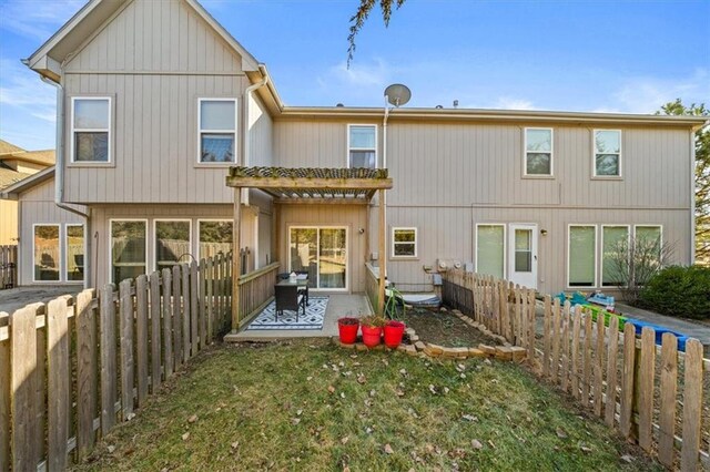 back of property with a patio, a yard, and a fenced backyard