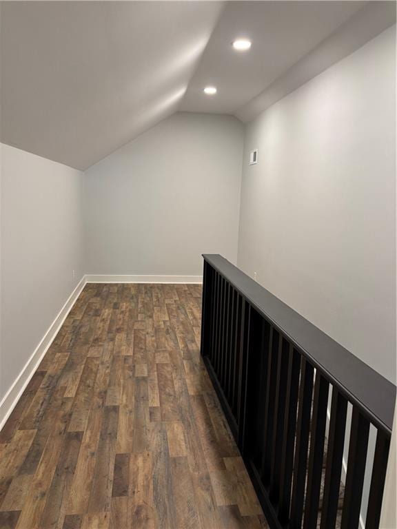 corridor with dark wood-style floors, baseboards, vaulted ceiling, and recessed lighting