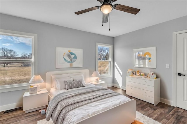 bedroom with dark wood-type flooring, visible vents, and baseboards