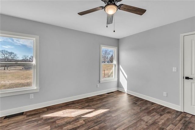 spare room with dark wood-style floors, baseboards, and visible vents