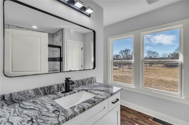 bathroom featuring visible vents, baseboards, wood finished floors, and vanity