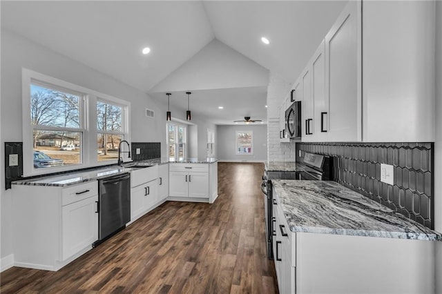 kitchen featuring light stone counters, pendant lighting, appliances with stainless steel finishes, white cabinets, and a peninsula