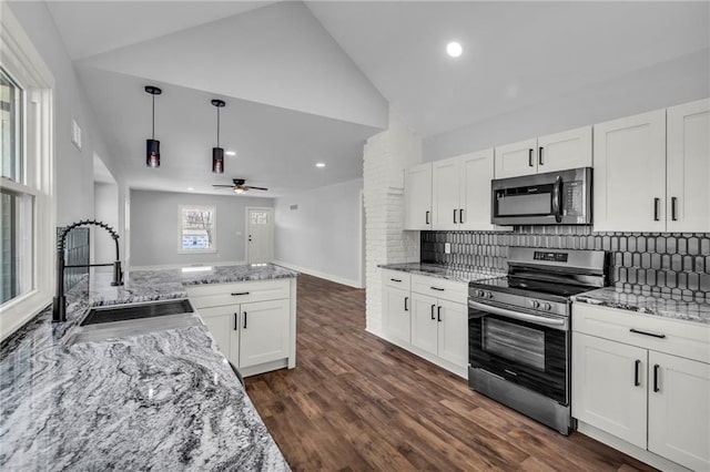 kitchen featuring a sink, white cabinets, hanging light fixtures, appliances with stainless steel finishes, and light stone countertops