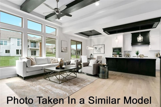 living room featuring coffered ceiling, ceiling fan, beam ceiling, and light hardwood / wood-style flooring