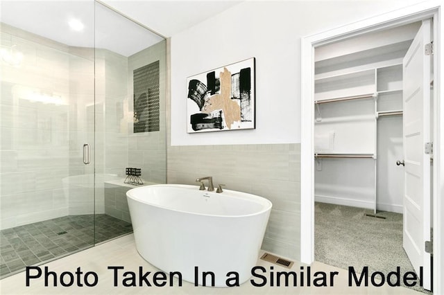 bathroom with independent shower and bath and tile walls