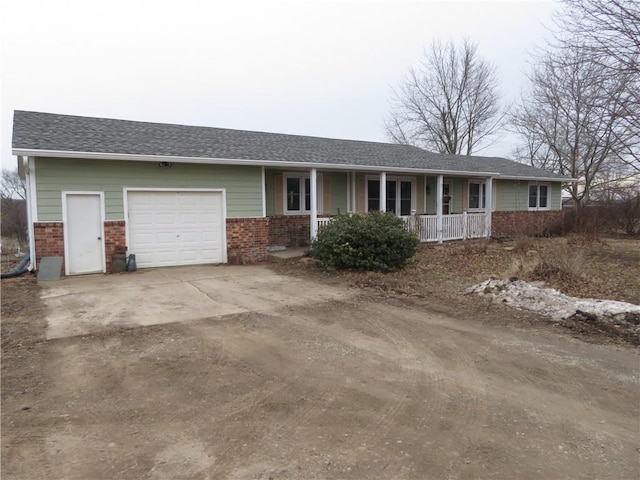 ranch-style home with a garage and covered porch