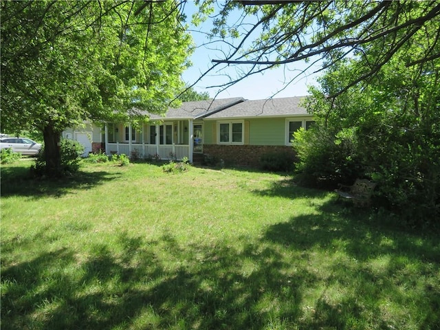 3242 K-237 Hwy, Perry, KS 66073 - rear view of house with brick siding, a yard, a shingled roof, and a porch