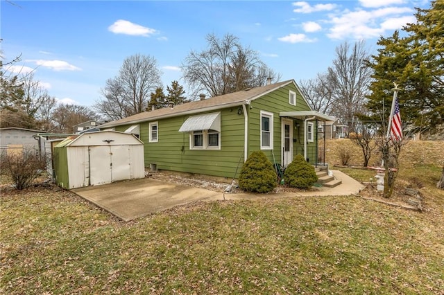 view of side of property with a shed, a lawn, and a patio area