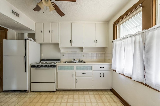 kitchen with white cabinetry, sink, and white appliances