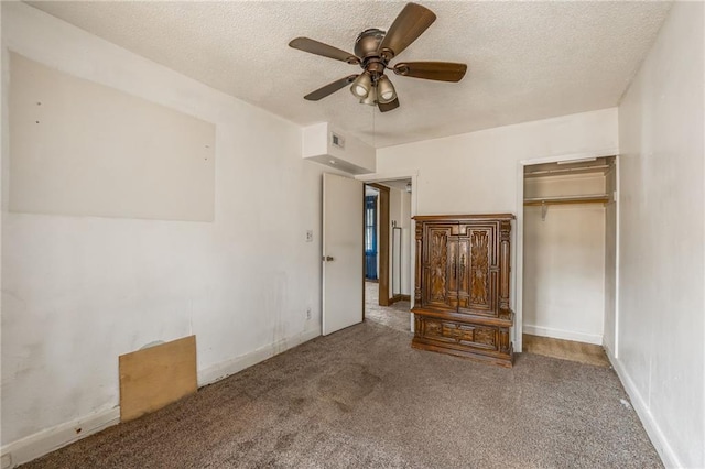 unfurnished bedroom with ceiling fan, carpet flooring, a textured ceiling, and a closet