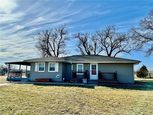 view of front of house featuring covered porch, an attached carport, and a front yard