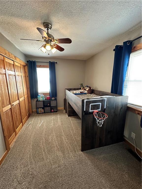 bedroom with a ceiling fan, carpet, multiple windows, and baseboards