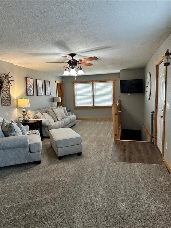 living room with a textured ceiling, carpet, a ceiling fan, and baseboards